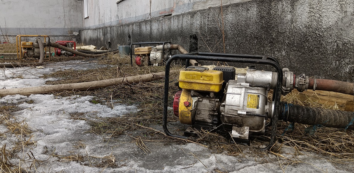 Откачка мотопомпами талой воды из подвала дома в Алтае Республике